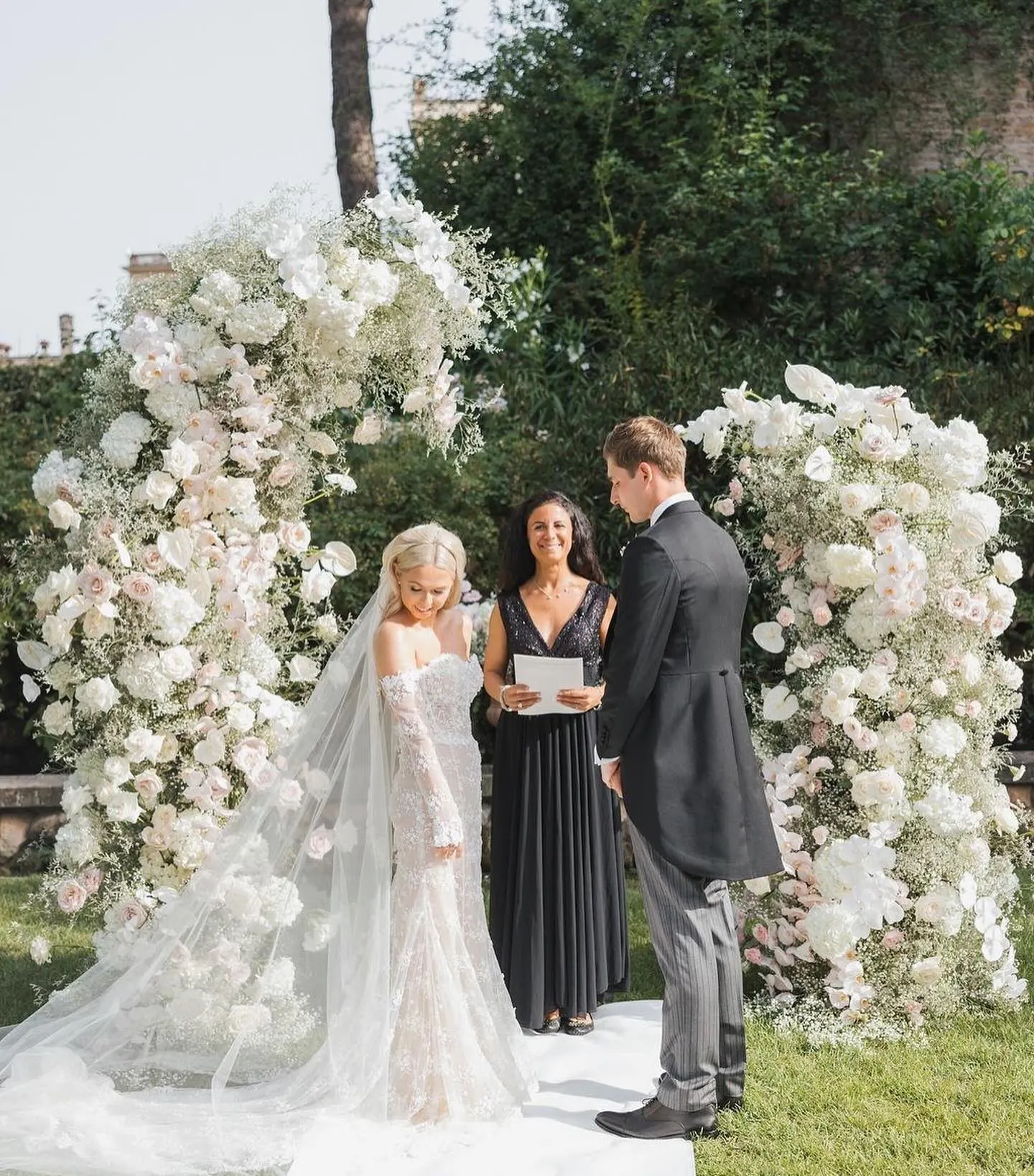Every ceremony comes with Couple under a white floral arch while their celebrant reads the ceremony