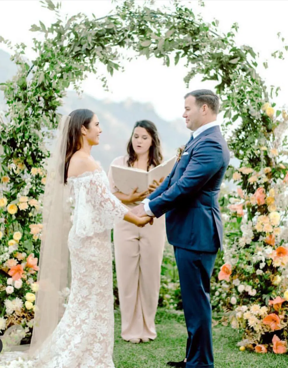 Priscilla Celebrant Priscilla leading a wedding ceremony under a flower arch on the Amalfi Coast