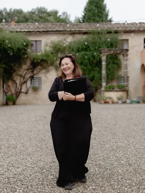 Simona Celebrant Simona smiling with her ceremony folder at a Tuscan villa