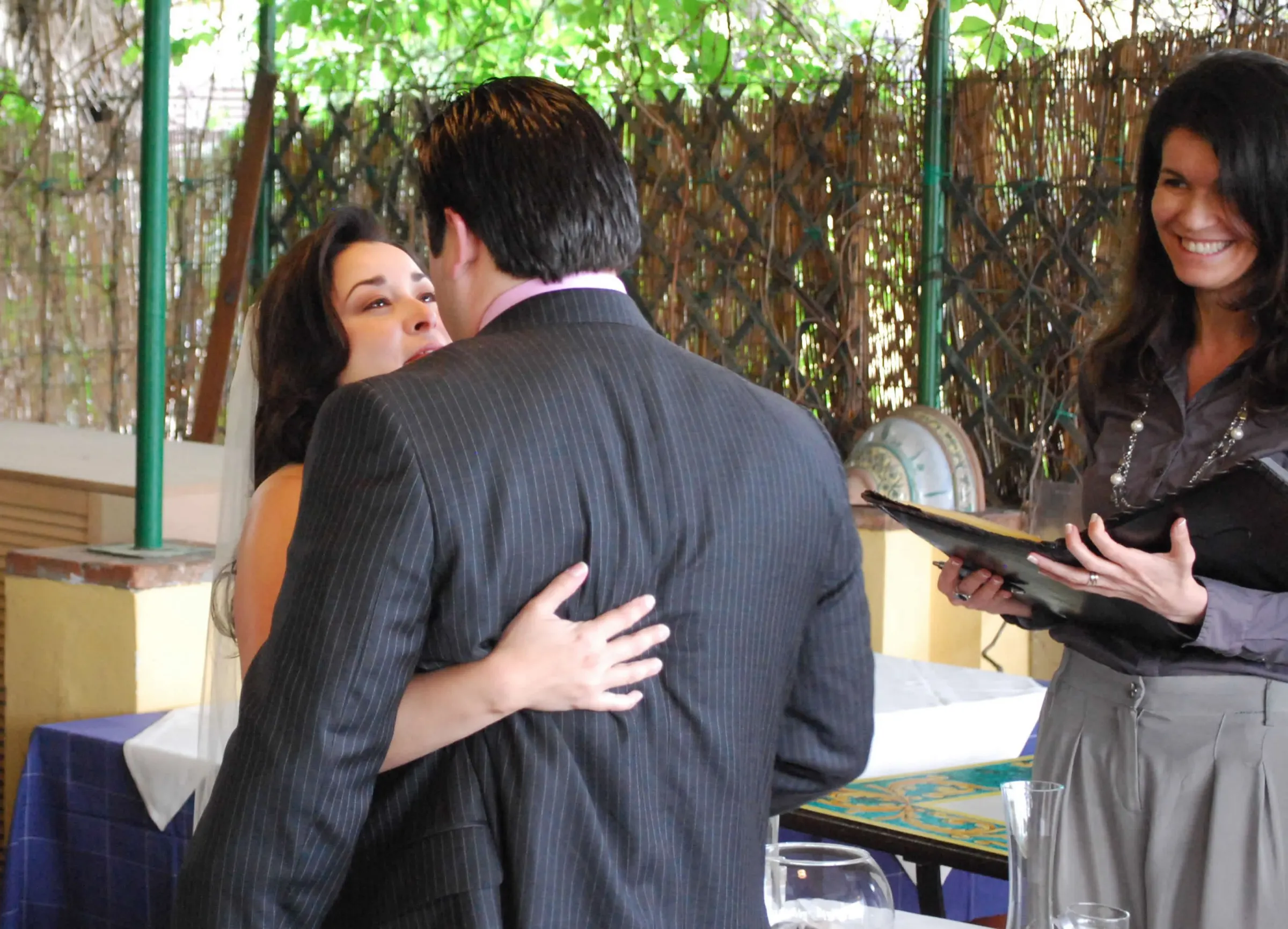 Vow renewals in Italy Couple embracing after their vows while the celebrant smiles