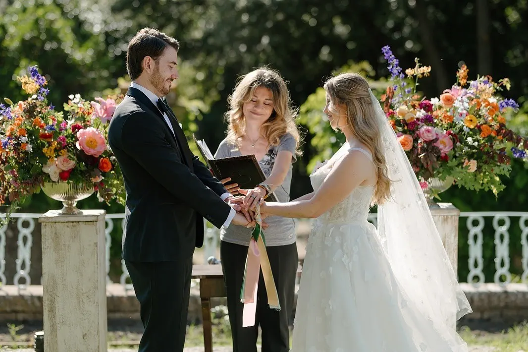 Symbolic ceremonies Celebrant tying coloured ribbons around the couple's hands in a handfasting ritual