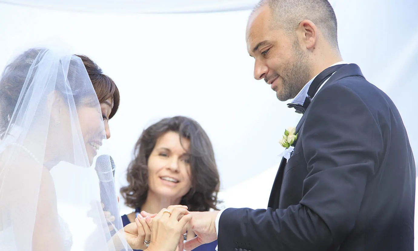 Foto: Rellini Art Studio Sposi si scambiano gli anelli mentre la celebrante sorride