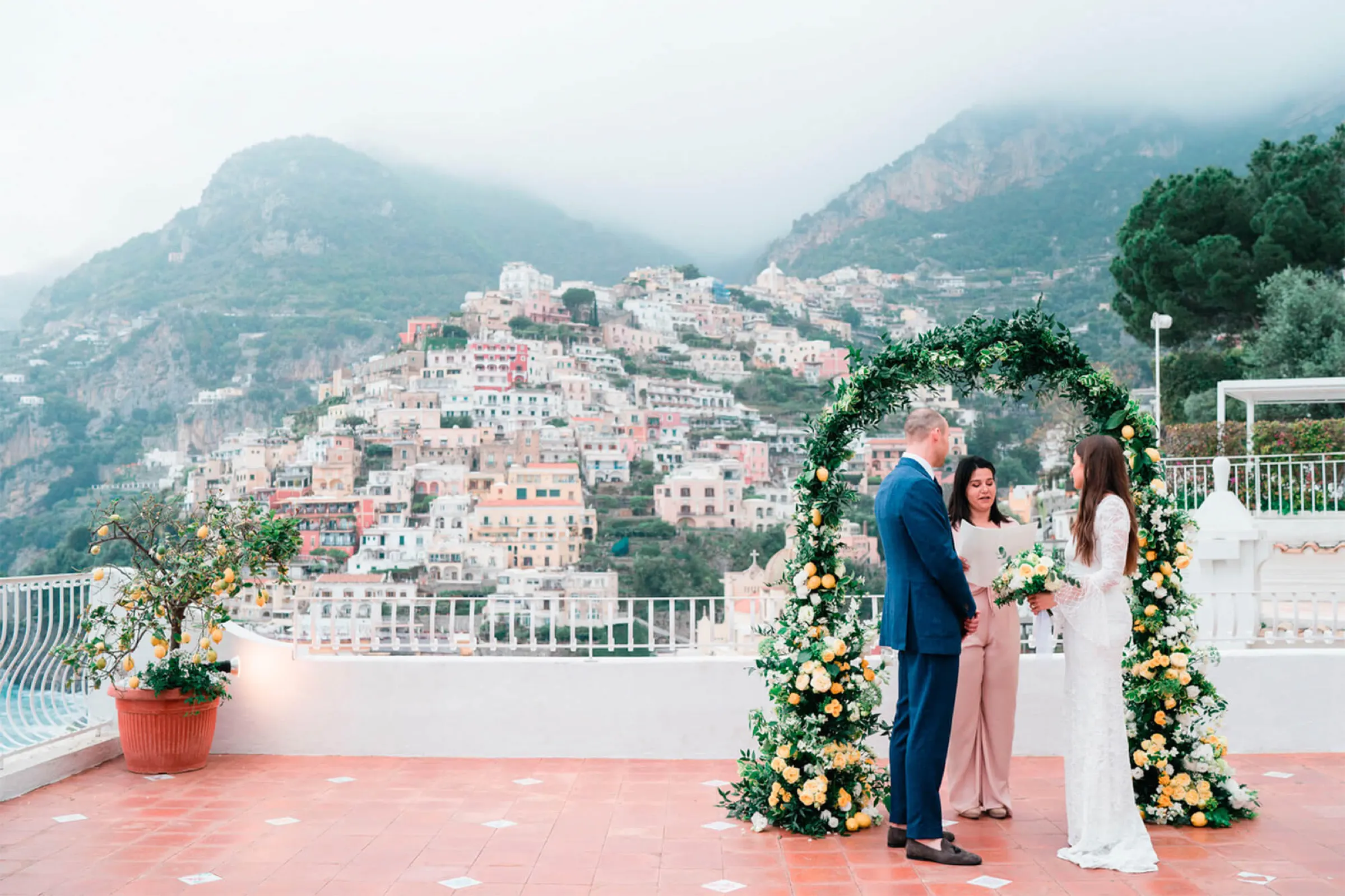 Wedding ceremony under a flower arch on a terrace overlooking Positano on the Amalfi Coast Wedding ceremony under a flower arch on a terrace overlooking Positano on the Amalfi Coast