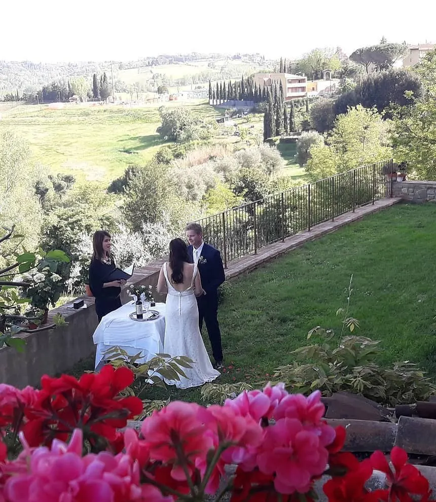 Elopements Celebrant leading an intimate ceremony for a couple on a garden terrace with a view of the hills