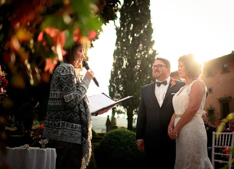 Photo: Andrea Corsi Celebrant leading a wedding ceremony at sunset in the garden of a Tuscan villa